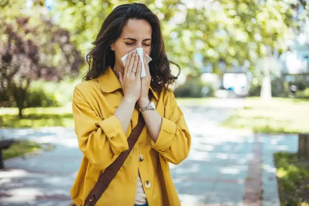 Person sneezing outdoors